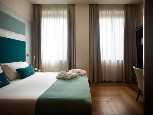 a bedroom with a large bed with blue and white sheets at Bianca Maria Palace Hotel in Milan
