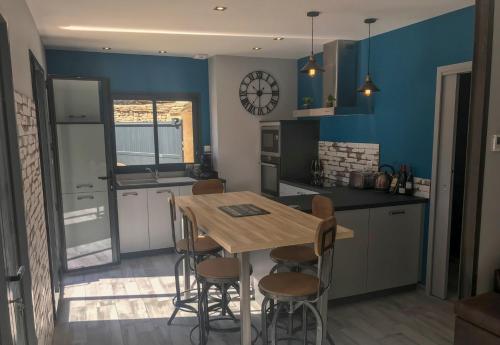 a kitchen with a wooden table and chairs in it at Le jardin des Arums in Givry