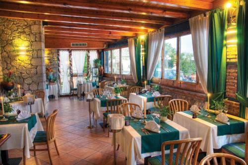 a restaurant with tables with green and white table settings at Hotel Ariston and Palazzo Santa Caterina in Taormina