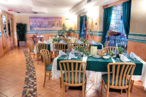 a dining room with green tables and chairs at Hotel Ariston and Palazzo Santa Caterina in Taormina
