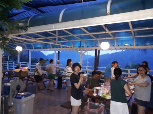 a group of people standing around a table on a patio at In Bali Inn in Luofu