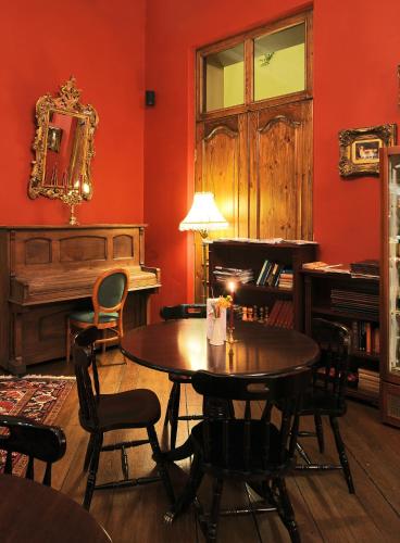 a living room with a table and a piano at Shakespeare Boutique Hotel in Vilnius