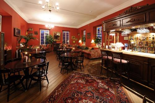 a restaurant with tables and chairs and a bar at Shakespeare Boutique Hotel in Vilnius
