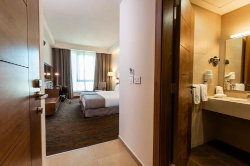 um quarto de hotel com uma cama e uma casa de banho em Citea Apart Hotel em Beirute