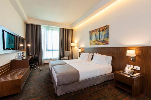 a hotel room with a large bed and a desk at Citea Apart Hotel in Beirut