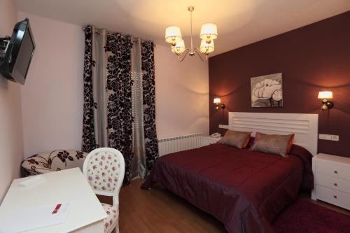 a bedroom with a bed and a table and a chair at Hotel HC Sigüenza in Sigüenza