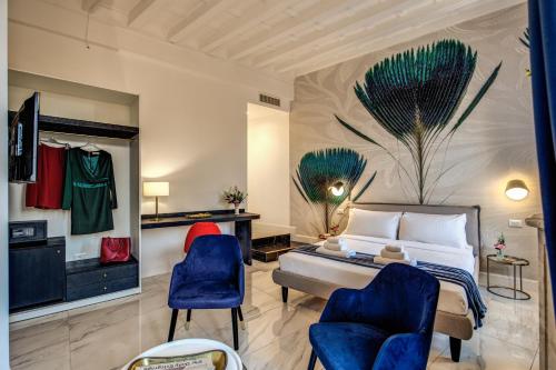 a bedroom with a bed and two blue chairs at Little Queen Pantheon in Rome