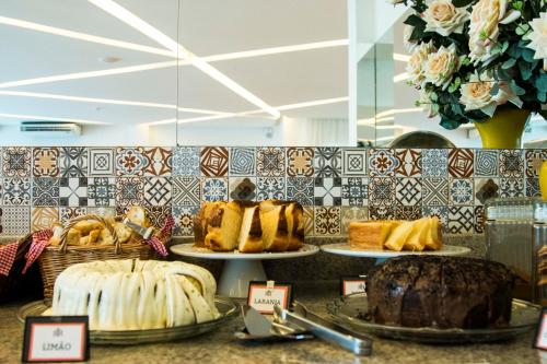 a bakery with different types of cakes on plates on a counter at Reserve Hotel in Surubim