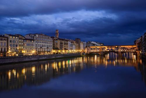 a bridge over a river in a city at night at Hotel Berchielli in Florence