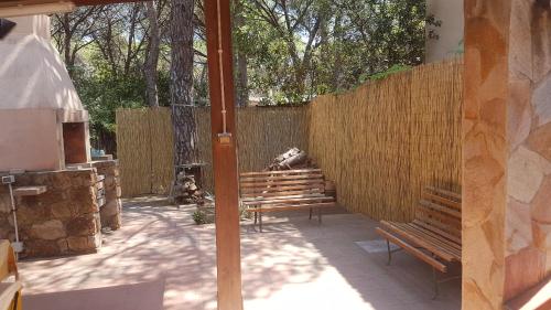 a patio with two benches and a fence at Mare a Santa Margherita in Pula