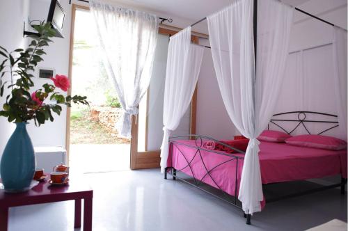 パトゥにあるB&B Yatabuiのベッドルーム1室(ピンクベッド1台、天蓋付)