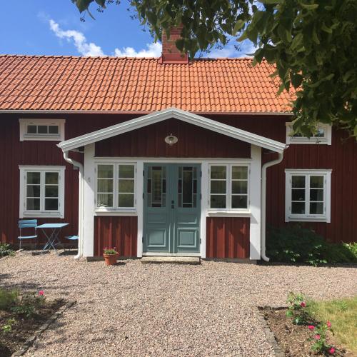 Vreta KlosterにあるGrönlundの赤い屋根と青い扉の赤い家