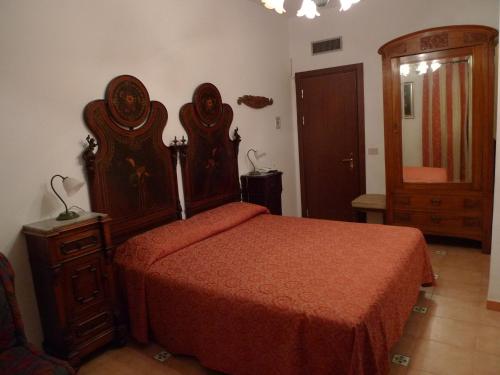 a bedroom with a large bed with a red bedspread at Hotel La Riva in Giardini Naxos