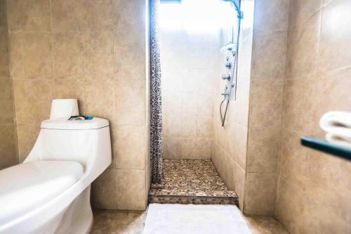 a bathroom with a shower with a toilet and a sink at La Dolce Vita in Esterillos