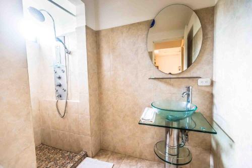 a bathroom with a sink and a shower with a mirror at La Dolce Vita in Esterillos
