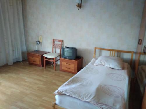 ウッチにあるZajazd Arka 2のベッドルーム(ベッド1台、テレビ、椅子付)