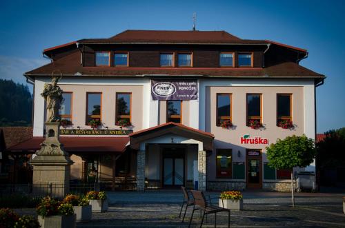 a large white building with chairs in front of it at Ubytování U Valašských ponožek in Hovězí