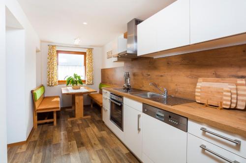 a kitchen with white cabinets and a table and a sink at Pension Anna in Mondsee