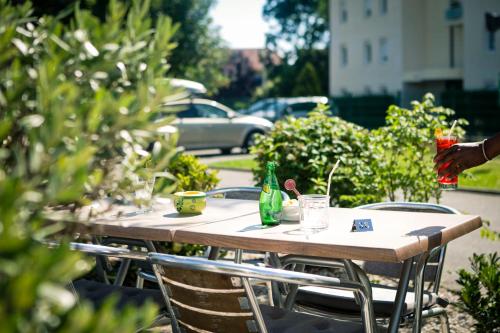 a wooden table with chairs and drinks on it at Campanile Genève - Ferney-Voltaire in Ferney-Voltaire
