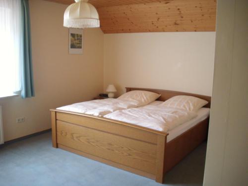 ゾルタウにあるHotel-Pension-Luisenhofのベッドルーム1室(木枠の大型ベッド1台付)