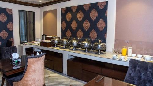 a buffet with many pots on a counter in a restaurant at Regency Inn in Lahore