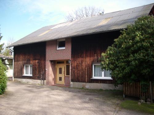 ein Holzhaus mit gelber Tür vorne in der Unterkunft Hotel-Pension-Luisenhof in Soltau