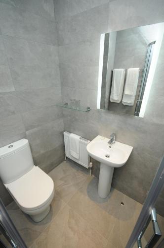 a white bathroom with a toilet and a sink at Lodge at The Old Barracks in Athenry