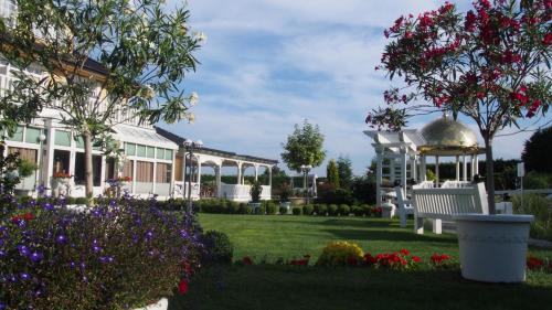 a garden with a white building and a gazebo at Dworek Hetmanski in Stargard