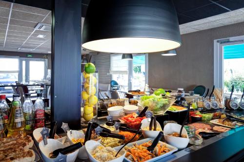a buffet line with many different types of food at Campanile Genève - Ferney-Voltaire in Ferney-Voltaire