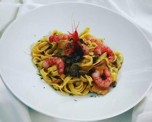 a plate of pasta with shrimp on a white plate at Hotel La Cavalera in Augusta