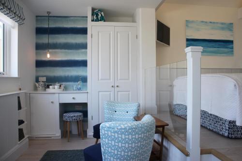 a bedroom with a bed and a chair and a table at Trevose Harbour House in St Ives