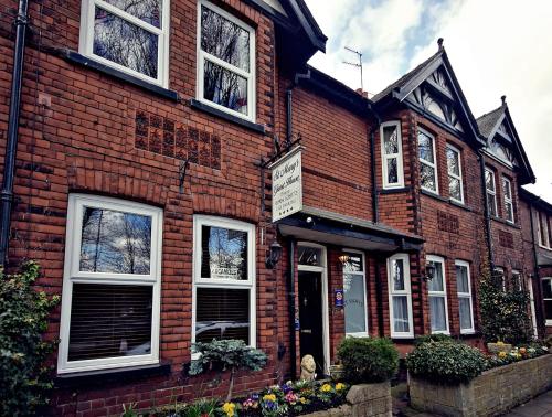 a red brick building with white windows on a street at St Marys Guest House in York