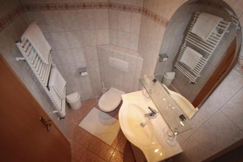 a bathroom with a sink and a toilet and a mirror at Haus Dorfblick in Gerlos