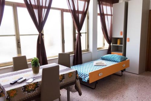 a dining room with a table and some windows at Forte apartments "Enjoy Salento" in Avetrana