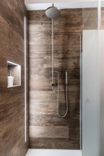 a bathroom with a shower with wooden walls at Apartment Valentina in Bressanone