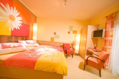 a bedroom with a bed with a flower on it at Malerwinkl Restaurant + Kunsthotel in Hatzendorf