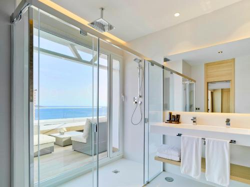 een badkamer met een glazen douche en uitzicht op de oceaan bij Hotel Don Pancho - Designed for Adults in Benidorm