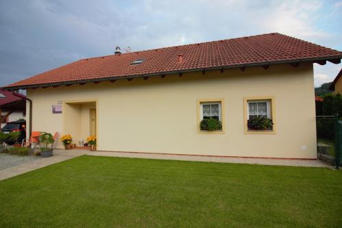 une maison avec une pelouse verte devant elle dans l'établissement Orange Loft Apartment, à Kájov
