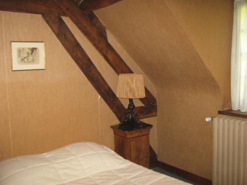 ein Schlafzimmer mit einem Bett und einer Lampe auf einem Tisch in der Unterkunft la maison d'hôtes de plessis in Plessis-Saint-Jean