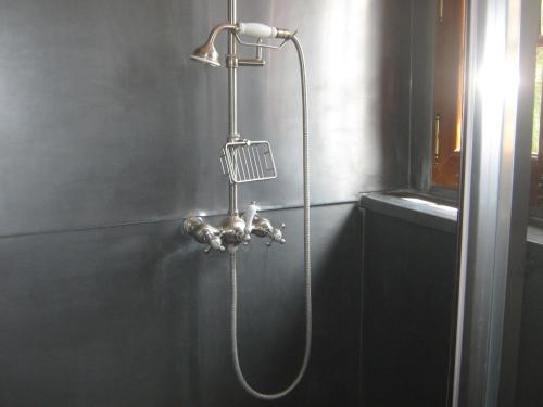 a shower with a hose attached to a wall at la maison d'hôtes de plessis in Plessis-Saint-Jean