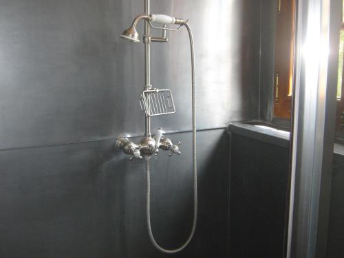 eine Dusche mit einem an der Wand befestigten Schlauch in der Unterkunft la maison d'hôtes de plessis in Plessis-Saint-Jean
