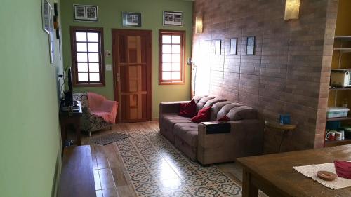 - un salon avec un canapé et une table dans l'établissement Aconchegante Casa, à São Lourenço