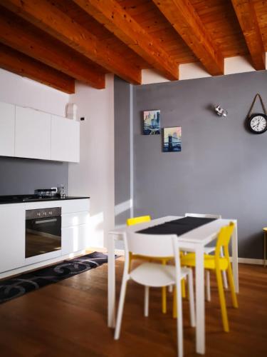 a kitchen with a white table and yellow chairs at Villa Zen 2 in Padova