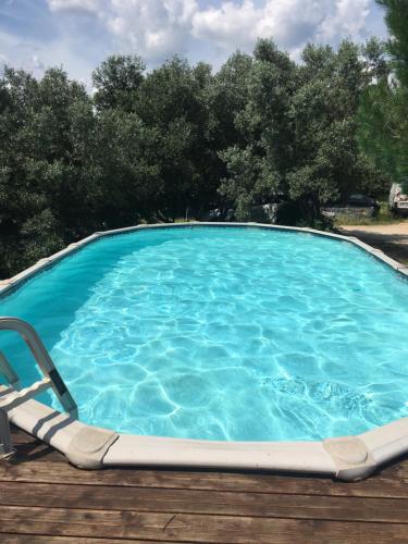 - une piscine avec une chaise et de l'eau bleue dans l'établissement Les insolites de Taracopala, à Solliès-Toucas