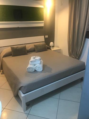a bedroom with a bed with towels on it at Park 20 Guesthouse in Olbia