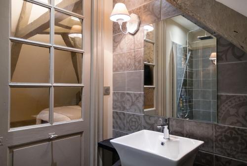 La salle de bains est pourvue d'un lavabo et d'un miroir. dans l'établissement Le Relais, à Bagnères-de-Bigorre