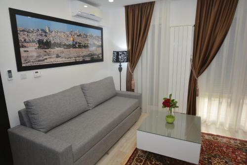 a living room with a couch and a tv on the wall at Apart Hotel Family in Sarajevo