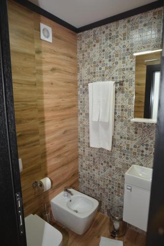 a bathroom with a sink and a toilet and a mirror at Apart Hotel Family in Sarajevo