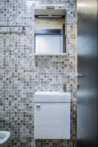 a bathroom with a toilet and a sink and a mirror at Apart Hotel Family in Sarajevo