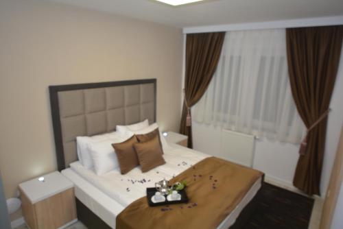 a bedroom with a large bed with a tray on it at Apart Hotel Family in Sarajevo